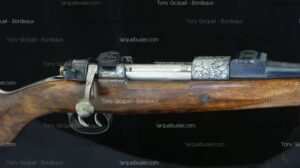 Carabine de chasse à crosse bois sombre. Détail de la culasse et des montages en métal gravé de motifs feuillagés. Textes: Tony Gicquel - Bordeaux, larquebusier.com.