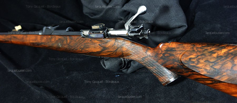 Carabine de chasse à verrou en bois précieux flammé avec quadrillage gravé, mécanisme métallique poli. Tony Gicquel - Bordeaux.