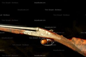 Fusil de chasse de luxe, finement gravé avec détails animaliers, crosse en bois veiné, sur fond sombre. Tony Gicquel - Bordeaux, larquebusier.com.
