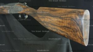 Fusil de chasse avec crosse en bois figuré et gravures. Présence des filigranes Tony Gicquel - Bordeaux et larquebusier.com.