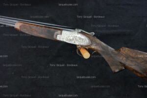Fusil de chasse juxtaposé, bascule finement gravée argentée, crosse en bois ronceux. Marquages Tony Gicquel - Bordeaux, larquebusier.com.