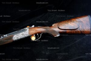 Fusil de chasse Tony Gicquel de Bordeaux, luxe avec crosse en bois veiné, gravures ornementales et mécanisme détaillé.
