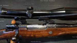 Carabine de chasse luxe, crosse bois, boîtier gravé or/argent, lunette de tir noire, logo et n°12267. Tony Gicquel - Bordeaux.