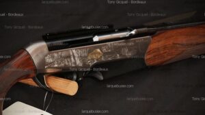 Carabine de chasse semi-automatique gravée d'une scène de forêt et d'un sanglier doré, crosse en bois texturé. Numéro F31129GN17 visible. Tony Gicquel - Bordeaux.