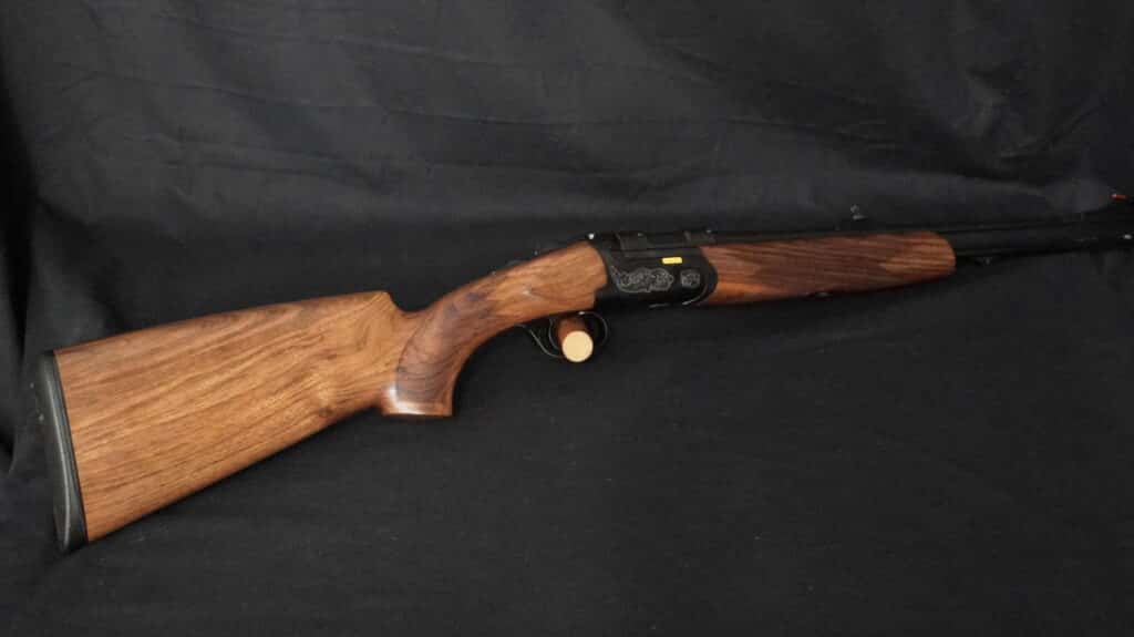 Carabine de chasse Sabatti en bois foncé, métal noir gravé et inscription dorée. Crosse texturée.