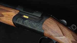 Gros plan d'un fusil de chasse Fabarm avec son récepteur noir mat finement gravé et sa crosse en bois texturée. Le nom FABARM est affiché en doré.
