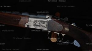 Fusil de chasse B3, boîtier argenté finement gravé de deux cerfs en forêt, crosse en bois foncé quadrillé. Artisanat armurier élégant.