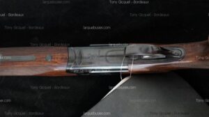 Fusil de chasse Beretta, crosse en bois foncé, boîtier de culasse en acier poli. Inscription "BERETTA" visible.