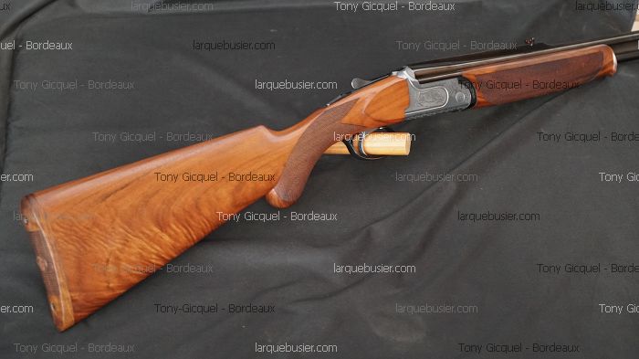 Fusil de chasse superposé, crosse et devant en bois clair flammé. Culasse gravée. Watermarks : Tony Gicquel - Bordeaux, larquebusier.com.
