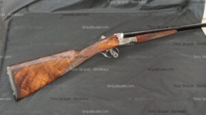 Fusil de chasse double canon à crosse en bois veiné. Récepteur argenté. Texte : Tony Gicquel - Bordeaux, larquebusier.com.