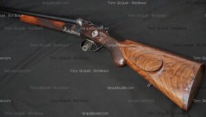 Fusil de chasse juxtaposé à double canon, crosse et devant en bois figuré. Action métallique finement travaillée. Tony Gicquel - Bordeaux.