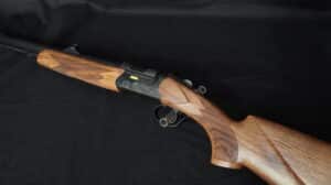 Fusil de chasse Fabarm à crosse en bois texturée et gravures sur le boîtier noir.