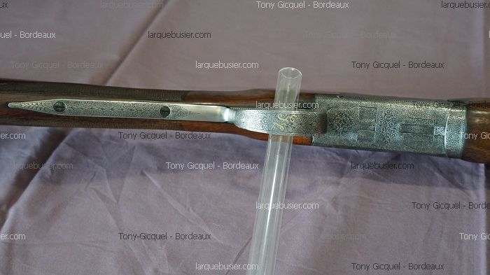 Gros plan d'un fusil de chasse à bois et métal finement gravé. Visible : Tony Gicquel - Bordeaux, larquebusier.com.