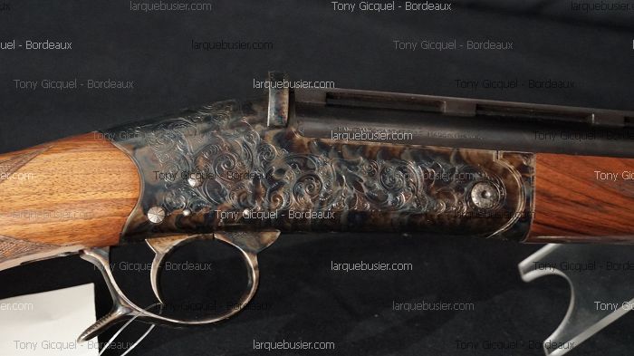 Détail d'un boîtier de culasse et crosse d'une arme à feu ornée de gravures florales. Inscription visible: "MANUFACTURE D'ARMES DE ST ETIENNE".