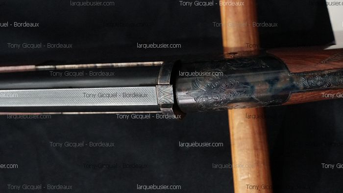 Détail d'un fusil de chasse: canon et bascule en acier gravé de volutes. Bois précieux. Watermarks Tony Gicquel - Bordeaux, larquebusier.com.
