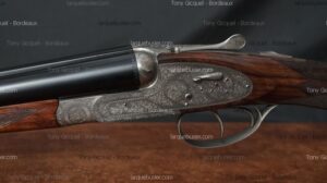 Fusil de chasse juxtaposé ancien, gravé, canons bronzés, crosse bois. Vendu par Tony Gicquel - Bordeaux.