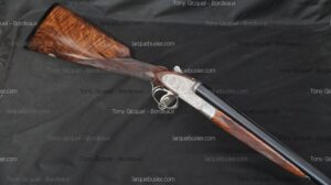Magnifique fusil de chasse superposé, crosse en noyer figuré et bascule en métal finement gravée.