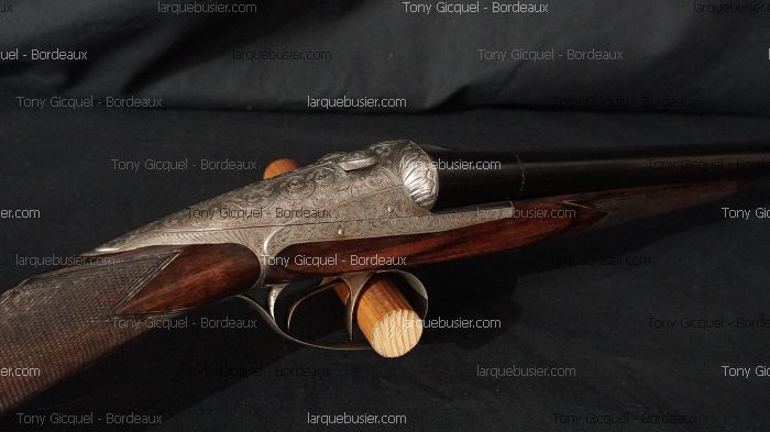 Fusil de chasse juxtaposé luxueux, finement gravé, avec crosse en bois et canons bronzés. Watermarks: larquebusier.com, Tony Gicquel - Bordeaux.
