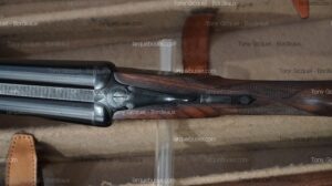 Fusil de chasse double-canon de luxe, crosse bois quadrillée, acier bleui, dans son étui. Tony Gicquel - Bordeaux, larquebusier.com.