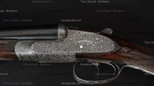 Fusil de chasse juxtaposé ancien avec platines finement gravées à volutes. Détail du nom 'MAINWARING' sur le boîtier de culasse argenté.