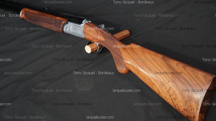 Fusil de chasse de sport en bois clair veiné et métal argenté. Crosse et devant détaillés. Marquage "Tony Gicquel - Bordeaux" et "larquebusier.com".