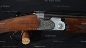 Fusil superposé : crosse bois quadrillée, bascule métal richement gravée, détente dorée. Marques "Tony Gicquel - Bordeaux", larquebusier.com.