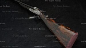 Fusil de chasse superposé, platines finement gravées, crosse en bois veiné foncé et embout violet. Filigranes Tony Gicquel - Bordeaux, larquebusier.com.