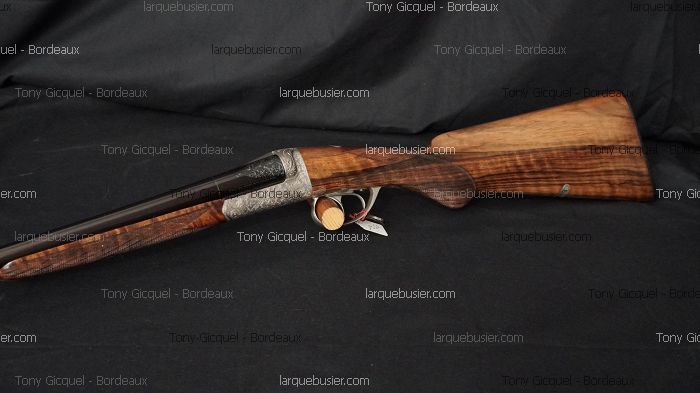 Fusil de chasse double canon, gravures ornées, crosse et devant en bois figuré. Watermarks : Tony Gicquel - Bordeaux, larquebusier.com.