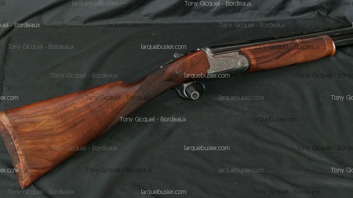 Fusil superposé avec crosse et devant en bois veiné, canon en métal. Marqueurs Tony Gicquel - Bordeaux et larquebusier.com.